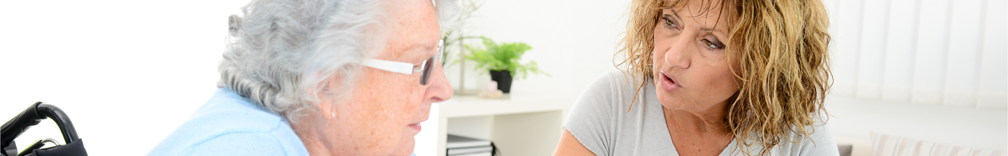 Forty-something female caregiver talking with her elderly mother about caregiving