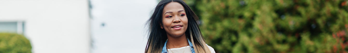 20-something woman smiling because she’s eligible for coverage due to Medicaid expansion