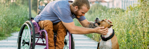 man-in-wheelchair-petting-dog