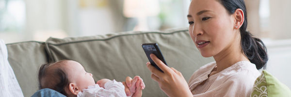 woman on cellphone with infant